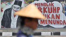 Mural bertulis 'Menolak RKUHP Bukan Menunda' terpampang pada dinding di Jalan Pemuda, Rawamangun, Jakarta, Selasa (1/10/2019). Mural tersebut respons dari seniman Jakarta terhadap RUU KUHP yang dinilai mencederai tatanan demokrasi. (merdeka.com/Iqbal Nugroho)