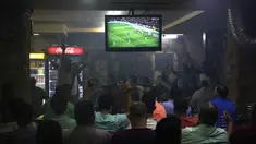 Warga Palestina menyaksikan pertandingan sepak bola El Clasico antara Real Madrid dan Barcelona FC di sebuah kafe di kota Ramallah, Tepi Barat (6/5). Real Madrid dan Barcelona meraih hasil imbang 2-2 di pertandingan tersebut. (AFP Photo/Abbas Momani)