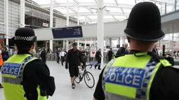 Petugas keamanan mengamati aktivitas di stasiun kereta Manchester Victoria, Inggris, (30/5). Sempat ditutup, stasiun kereta Manchester Victoria kembali dibuka setelah lebih dari sepekan insiden bom bunuh diri di Manchester Arena (Owen Humphreys/PA via AP)
