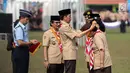 Presiden Joko Widodo memberi penghargaan kepada pramuka berprestasi saat acara Peringatan Hari Pramuka dan Pembukaan Raimuna Nasional XI Gerakan Pramuka di Bumi Perkemahan Cibubur, Jakarta, Senin (13/8). (Liputan6.com/Faizal Fanani)