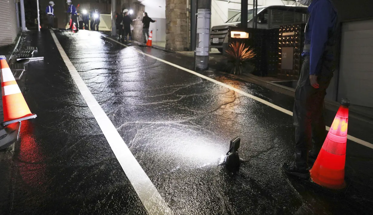 Sebuah jalan terendam air setelah gempa bumi di daerah perumahan di Tokyo, Jumat (8/10/2021) pagi. Gempa kuat mengguncang daerah Tokyo pada Kamis malam, menghentikan perjalanan kereta api dan kereta bawah tanah. (Kyodo News via AP)