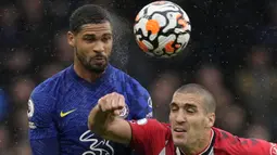 Gelandang Chelsea, Ruben Loftus-Cheek berduel udara dengan gelandang Southampton, Oriol Romeu dalam laga yang diguyur hujan di Stamford Bridge. (AP/Kirsty Wigglesworth)