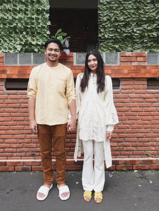 Penampilan manis dari pasangan Mikha Tambayong dan Deva Mahenra. Mikha memilih outfit beraksen tumpuk berwarna putih gading, sedangkan Deva tampil sederhana mengenakan atasan baju koko kuning dan celana panjang cokelat. [Foto: Instagram/miktambayong]