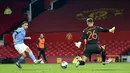 Pemain Manchester City, Phil Foden, melepaskan tendangan ke gawang Manchester United pada laga Piala Liga Inggris di Stadion Old Trafford, Rabu (6/1/2021). City menang dengan skor 2-0. (Peter Powell/Pool via AP)