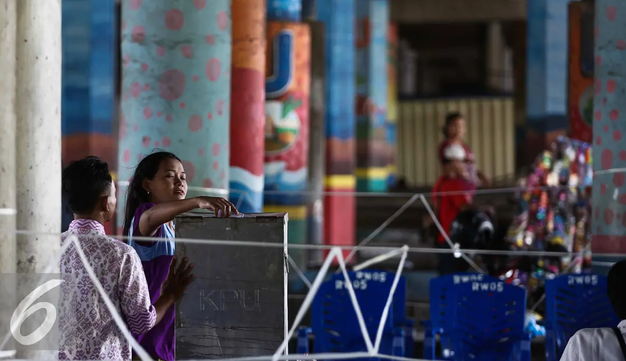 Warga memasukan kertas suara ke kotak saat melakukan pemilihan Pilkada DKI Jakarta di TPS 21 di bawah kolong jembatan tol akses Bandara, Petak Asem, Jakarta, Rabu (15/2). (Liputan6.com/Faizal Fanani)
