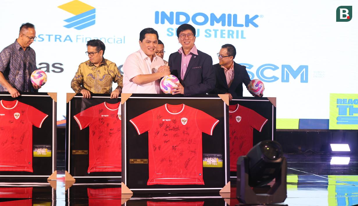 Direktur Utama SCM, Sutanto Hartono (kanan) bersama Ketua Umum PSSI, Erick Thohir, bersamalaman dengan simbolis menyerahkan bola dan jersey Timnas Indonesia tanda simbolis perpanjangan kerja sama antara SCM dengan PSSI dilakukan dalam PSSI Partner Summit 2024 di Hotel Park Hyatt, Jakarta Pusat, pada Senin (16/12/2024). (Bola.com/Abdul Aziz)