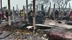 Pengungsi Rohingya berjalan di sisa-sisa yang hangus setelah kebakaran terjadi di Kamp Nayapara di distrik Cox's Bazar, Bangladesh, Kamis (14/1/2021). Ratusan rumah yang menjadi tempat tinggal ribuan pengungsi Rohingya hancur akibat dilalap api. (AP Photo/Mohammed Faisal)