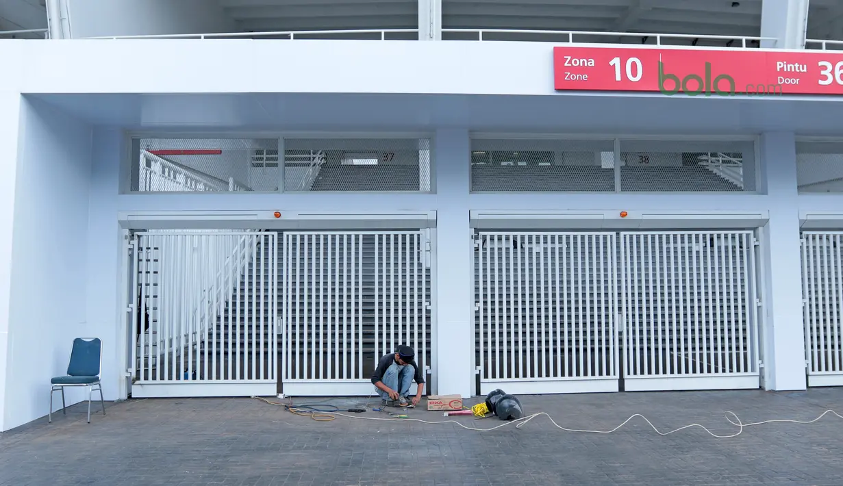 Pekerja sedang memperbaiki pintu stadion yang rusak pada laga Final Piala Presiden 2018 di Stadion Utama Gelora Bung Karno, Kamis (22/2/2018). Empat pintu stadion yang mengalami kerusakan adalah zona bernomor 5B, 7B, 9, dan 10. (Bola.com/Nick Hanoatubun)