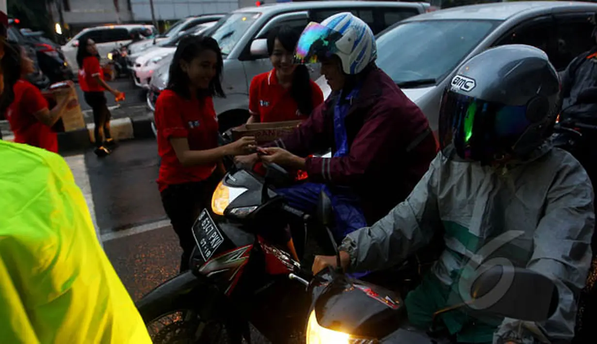 Sejumlah pengendara roda dua mendapatkan bingkisan coklat fullo sebagai apresiasi disiplin berlalu lintas di kawasan perempatan Cideng, Jakarta, Senin (23/2). (Liputan6.com/Johan Tallo)