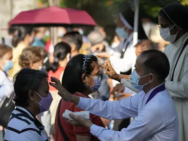 Warga berbaris agar dahi mereka ditandai dengan salib abu di Gereja Redemptorist selama upacara Rabu Abu di Manila, Filipina (2/3/2022). Jutaan orang Filipina beramai-ramai ke gereja dan dahi mereka ditandai dengan salib abu untuk memperingati Rabu Abu. (AP Photo/Aaron Favila)