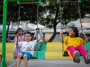 Anak-anak bermain ayunan di Ruang Publik Terbuka Ramah Anak (RPTRA) Rusun Petamburan, Jakarta, Selasa (9/10). Pemprov DKI Jakarta memangkas anggaran pembangunan RPTRA. (Liputan6.com/Faizal Fanani)