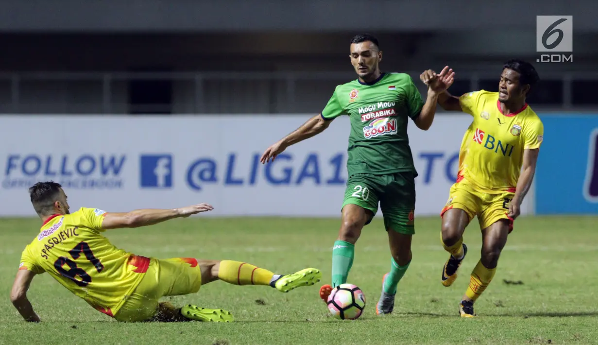 Pemain anyar PS TNI, Redouane Zerzori (tengah) berusaha lolos dari kawalan pemain Bhayangkara FC, Ilija Spasojevic saat lanjutan Liga 1 Indonesia di Stadion Pakansari, Kab Bogor, Minggu (3/9). PS TNI kalah 0-1. (Liputan6.com/Helmi Fithriansyah)