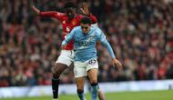 Gelandang Manchester United asal Inggris bernomor punggung 37, Kobbie Mainoo, berduel dengan bek Manchester City asal Inggris bernomor punggung 82, Rico Lewis, selama pertandingan Liga Inggris antara Manchester United dan Manchester City di Old Trafford, Manchester, barat laut Inggris, pada 17 Januari 2026. (Darren Staples/AFP)