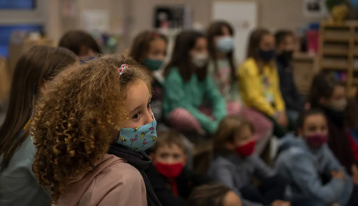 Siswa sekolah dasar melanjutkan kelas setelah liburan Natal di Barcelona, Spanyol, Senin (10/1/2022). Sekitar 8 juta siswa sekolah dasar dan menengah melanjutkan kelas setelah libur panjang Natal dan Tahun Baru meskipun ada prevelance yang mengkhawatirkan dari varian omicron. (AP/Emilio Morenatti)
