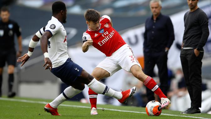 Bek Arsenal, Kieran Tierney berusaha melewati bek Tottenham Hotspur, Serge Aurier pada pertandingan lanjutan Liga Inggris di Stadion Tottenham Hotspur di London, Inggris, Minggu (12/7/2020). Tottenham menang tipis atas Arsenal 2-1. (Tim Goode/Pool via AP)