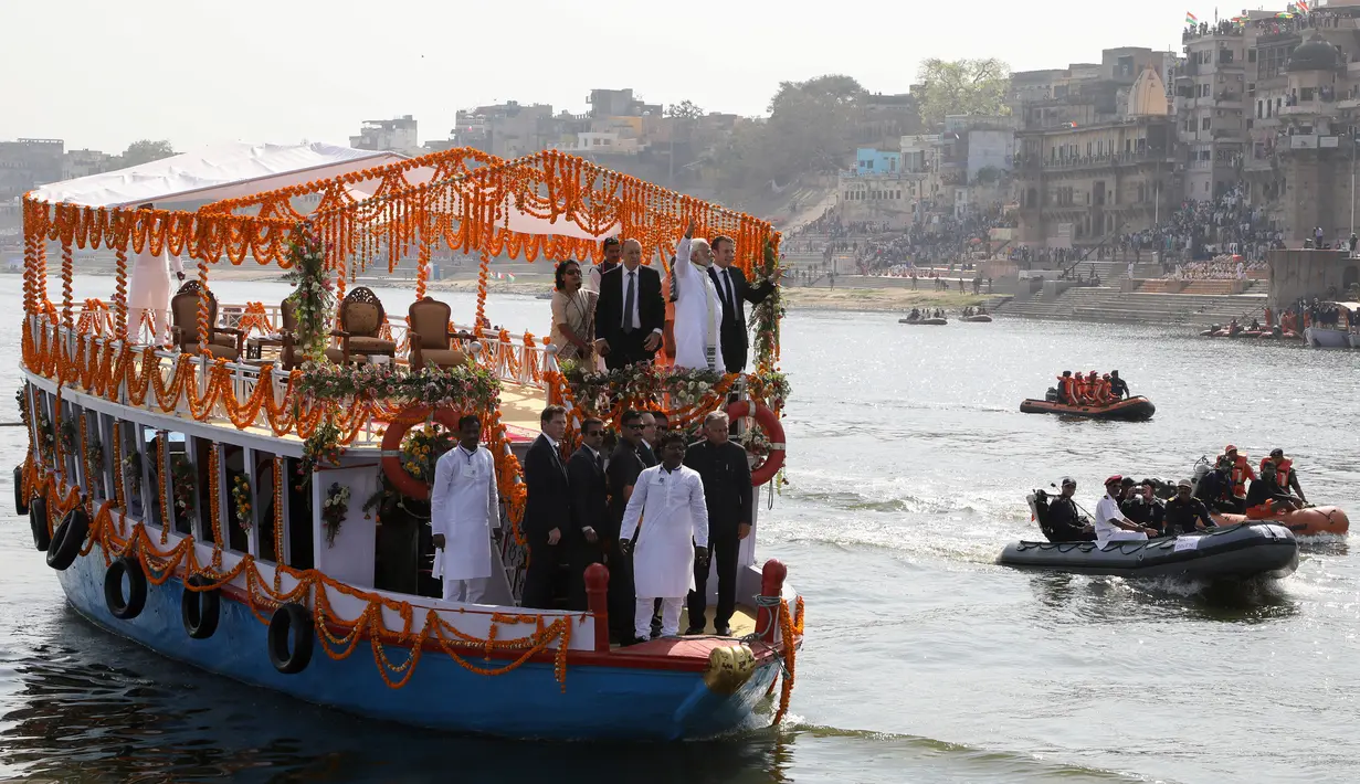 Suasana saat Presiden Prancis Emmanuel Macron (kanan atas) dan Perdana Menteri (PM) India Narendra Modi (tengah atas) naik perahu menyusuri Sungai Gangga di Varanasi, India, Senin (12/3). (AFP PHOTO/POOL/Ludovic MARIN)