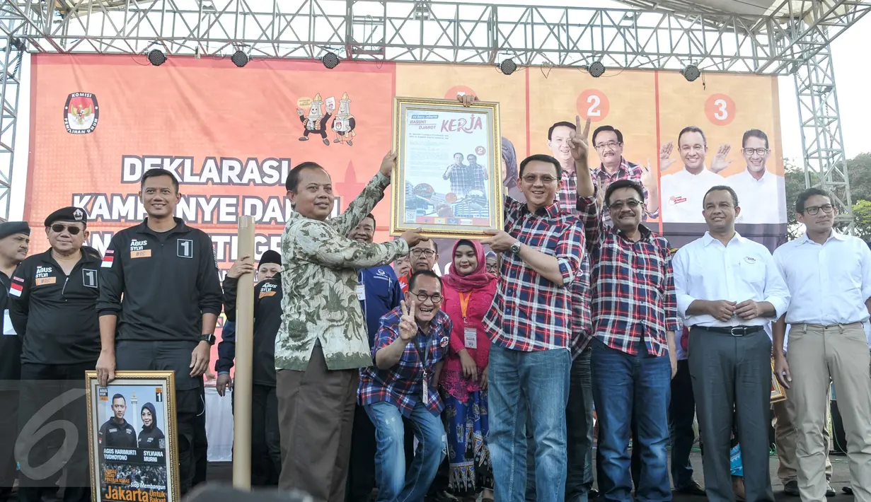 Ketua KPU DKI Jakarta, Sumarno menyerahkan simbolis alat peraga kampenya kepada pasangan calon Gubernur DKI Jakarta saat acara Deklarasi Kampanye Damai di Silang Monas, Jakarta, Sabtu (29/10). (Liputan6.com/Yoppy Renato)