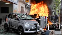 Sejumlah kendaran dibakar saat terjadi aksi demonstrasi pada peringatan Hari Buruh di Paris, Prancis (1/5). Hari Buruh pada umumnya dirayakan pada tanggal 1 Mei, dan dikenal dengan sebutan May Day. (AFP/Alain Jocard)