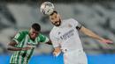 Striker Real Madrid, Karim Benzema (kanan) berduel udara dengan bek Real Betis, Emerson dalam laga lanjutan Liga Spanyol 2020/2021 pekan ke-33 di Alfredo Di Stefano Stadium, Madrid, Sabtu (24/4/2021). Real Madrid bermain imbang 0-0 dengan Real Betis. (AP/Bernat Armangue)