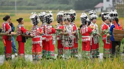 Warga yang mengenakan pakaian tradisional berkeliling untuk memperingati panen raya di Desa Dangzao, Panshi, Kota Tongren, Provinsi Guizhou, China, 20 September 2020. Berbagai aktivitas digelar di seluruh negeri untuk menyambut festival panen petani China ketiga pada 22 September. (Xinhua/Long Enze)
