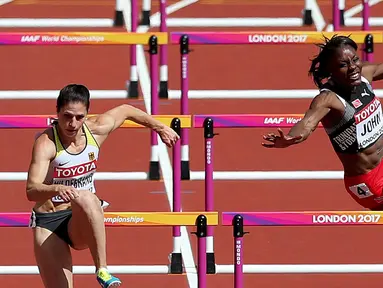 Atlet asal Trinidad dan Tobago, Deborah John (kanan) kehilangan keseimbangan saat melewati rintangan kelima dalam cabang lari halang rintang 100 meter putri Kejuaraan Atletik Dunia yang digelar di Stadion London, Inggris (11/8). (Jonathan Brady/PA via AP)