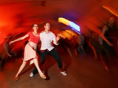 Para pengunjng asyik menari ketika menikmati alunan musik di Bar Claerchens Ballhaus di Berlin, Jerman, (31/8). Gemerlap kehidupan malam di Berlin dilewatkan ribuan warga setempat dengan berpesta di bar atau kelab. (REUTERS/Hannibal Hanschke)