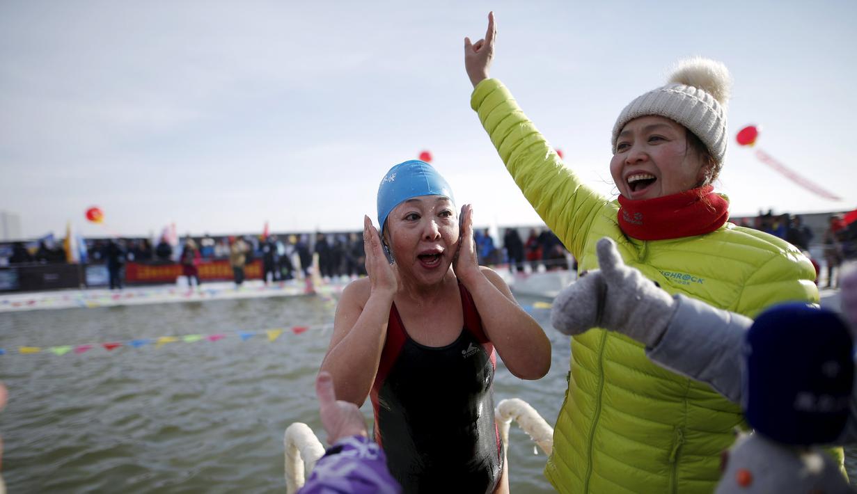 Reaksi salah satu peserta seusai menyelesaikan Kompetisi Renang Es Harbin di Sungai Songhua yang membeku di Provinsi Heilongjiang, Senin (5/1/2016). (REUTERS/Aly Song)