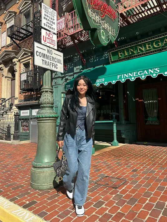 Gaya liburan Wendy Walters yang chic. Ia mengenakan atasan biru navy ditumpuk dengan jaket kulit hitam, dan celana jeans. [Foto: Instagram/wendywalters]