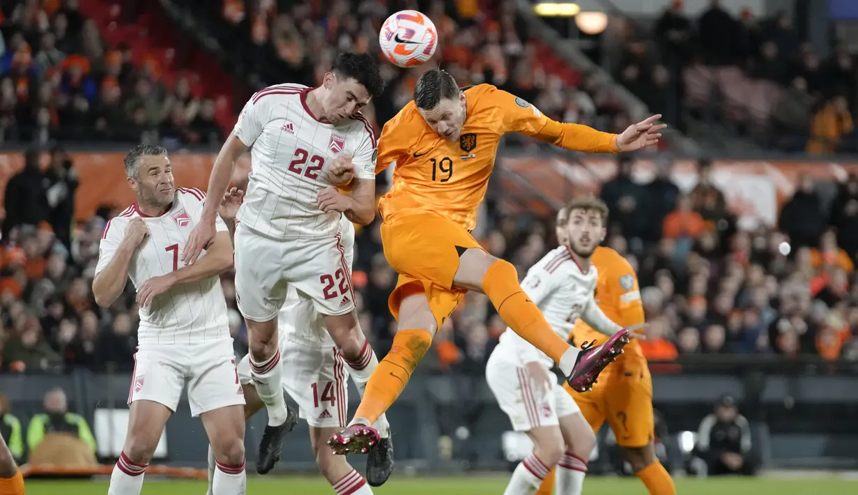 Pemain Timnas Belanda, Wout Weghorst (kanan) berebut bola dengan pemain Timnas Gibraltar, Graeme Troilla pada laga Grup B Kualifikasi Euro 2024 di Feyenoord Stadium, Rotterdam, Belanda, Selasa (28/03/2023) WIB. De Oranje menang dengan skor 3-0. (AP Photo/Peter Dejong)