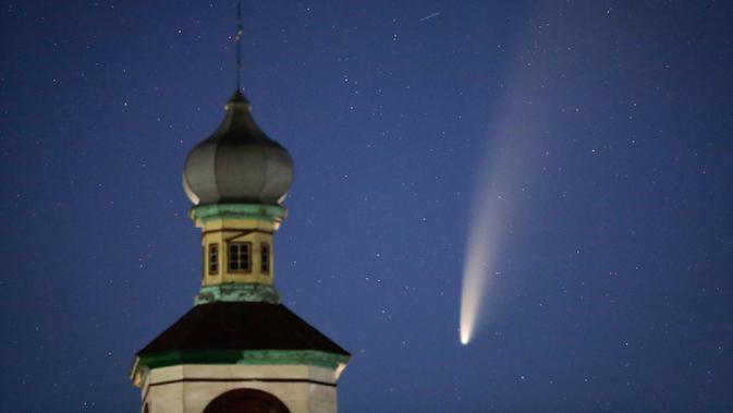 Komet Neowise atau C / 2020 F3 terlihat di belakang sebuah gereja Ortodoks di langit Turet, Belarus, 110 kilometer (69 mil) barat ibu kota Minsk, Selasa (14/7/2020) pagi. Bulan ini, komet Neowise melintasi tata surya bagian dalam untuk pertama kalinya dalam 6.800 tahun. (AP Photo/Sergei Grits)