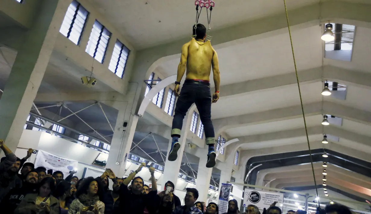 Seoranng digantung dengan dipasangkan sebuah besi (piercing) selama acara Tattoo and Suspension Convention di Valparaiso, Chili, (8/11/2015). Acara ini merupakan kegiatan untuk para penyuka tato dan modifikasi tubuh di Chili.  (REUTERS/Rodrigo Garrido)