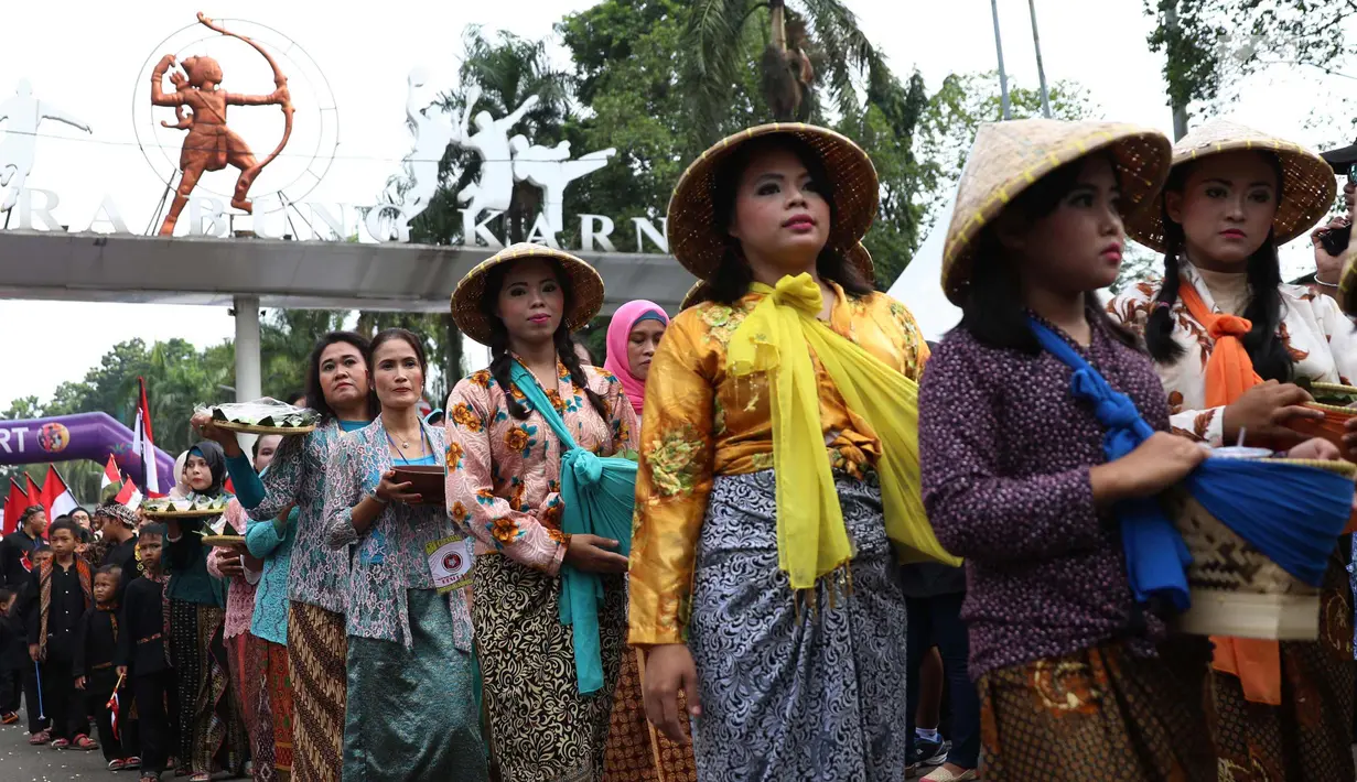 Sejumlah wanita mengenakan pakaian adat saat melakukan karnaval di jalan Pintu 1 Senayan, Jakarta, Minggu (24/9). Karnaval tersebut dilakukan dalam rangka HUT Gelora Bungkarno yang ke-55. (Liputan6.com/Angga Yuniar)