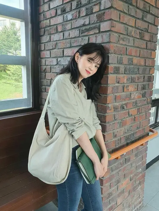 Memerankan karakter Yo Na Bi, seorang mahasiswa seni, Han So Hee kerap berpenampilan simpel. Salah satunya dengan memadukan shirt dan celana jeans. Ia juga melengkapi penampilannya dengan tote bag. (Instagram/xeesoxee).
