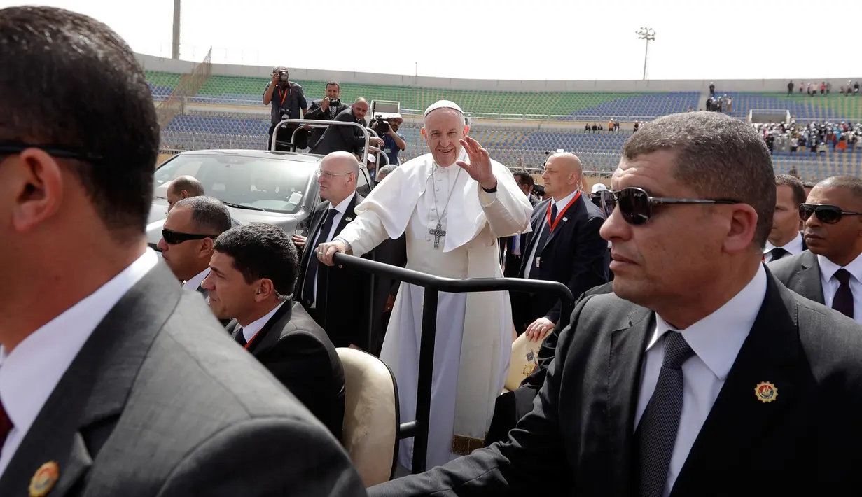 Paus Fransiskus melambaikan tangan saat tiba di stadion militer Kota Kairo, Mesir, (29/4). Kunjungan Paus Fransiskus juga untuk memperbaiki hubungan antara Gereja Katolik Roma dan para pemimpin Muslim. (AP Photo/Gregorio Borgia)