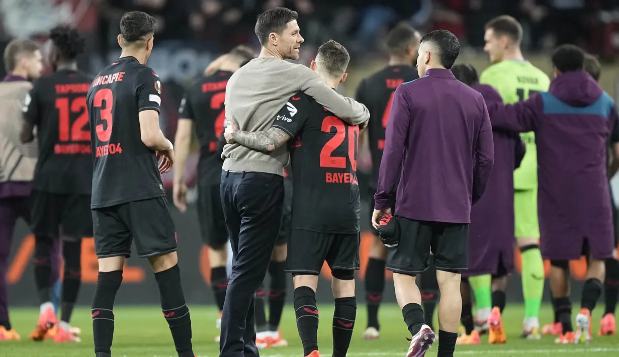 Pelatih Bayer Leverkusen, Xabi Alonso, bersama Alex Grimaldo  merayakan kemenangan atas West Ham United pada laga Perempat final Liga Europa di Stadion BayArena, Jumat (12/4/2024). Pasukan Xabi Alonso baru bisa mencetak dua gol pada ujung pertandingan berkat pemain pengganti mereka yaitu Jonas Hoffmann dan Victor Boniface. (AP Photo/Martin Meissner)