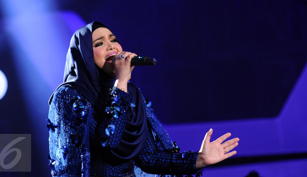Penyanyi asal Malaysia, Siti Nurhaliza saat tampil di Konser Kemenangan D'Academy Asia 2 di Studio 5 Indosiar, Jakarta, Kamis (29/12). Siti tampil memukau dengan menyanyikan dua lagu hitsnya. (Liputan6.com/Helmi Fithriansyah)