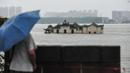 Warga memandangi kuil Guanyinge berumur 700 tahun yang dibangun di atas batu, terendam banjir akibat meluapnya sungai Yangtze di Wuhan, provinsi Hubei pada 19 Juli 2020. Hujan lebat sejak bulan Juni telah menyebabkan sedikitnya 141 orang tewas dan memaksa hampir 15 juta orang dievakuasi. (STR/AFP)