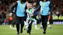 Fans cilik tersebut akhirnya digiring ke luar lapangan oleh petugas keamanan dengan ekspresi haru sambil memegang erat-erat jersey idolanya tersebut. (AFP/Paul Faith)