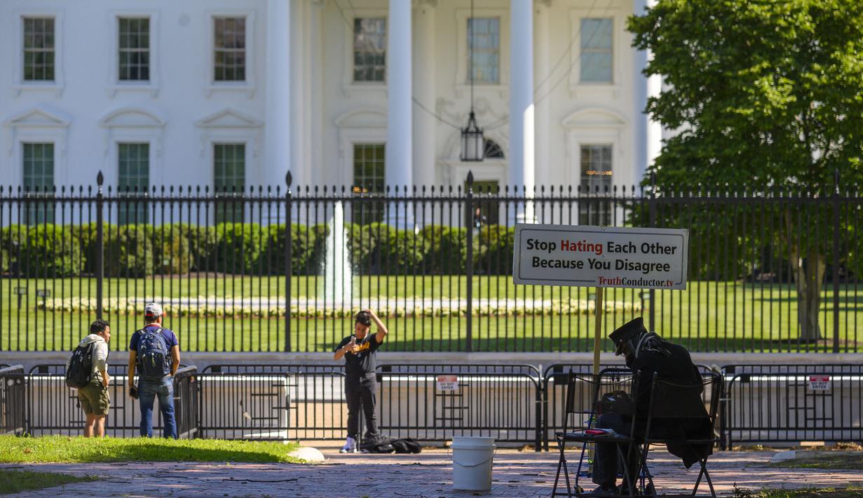Seorang aktivis perdamaian terlihat di Lafayette Square dekat Gedung Putih di Washington, DC, Selasa (10/5/2021). Lafayette Square dibuka kembali untuk pejalan kaki hampir setahun setelah daerah itu dipagari ketika demonstrasi membesar sebagai tanggapan atas kematian George Floyd. (Eric BARADAT/AFP)