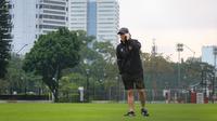 Pelatih Timnas Indonesia, Shin Tae-yong sedang menelpon saat latihan Timnas Indonesia menjelang laga leg pertama semifinal Piala AFF 2022 menghadapi Vietnam di Lapangan A, Kompleks Gelora Bung Karno, Jakarta, Rabu (04/01/2023). (Bola.com/Bagaskara Lazuardi)