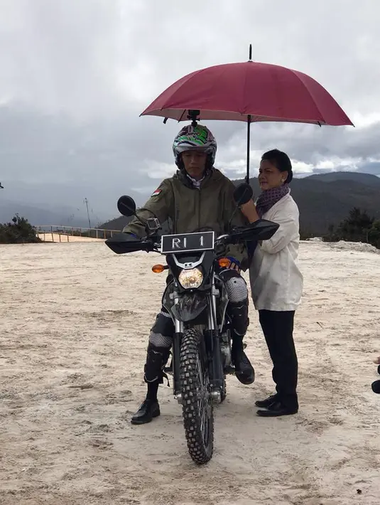 Ibu Negara, Iriana berpose memayungi Presiden Joko Widodo (Jokowi) disela konvoi menggunakan motor trail saat meninjau langsung pembangunan Jalan Trans Papua ruas Wamena-Mamugu 1 di Wamena, Kabupaten Jayawijaya, Papua, Rabu (10/5). (Dok. Biro Pers)