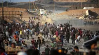 Warga Palestina berkumpul di titik distribusi bantuan yang didirikan oleh Yayasan Kemanusiaan Gaza (GHF) di dekat kamp pengungsi Nuseirat, Jalur Gaza Tengah pada 25 Juni 2025. (Eyad BABA/AFP)