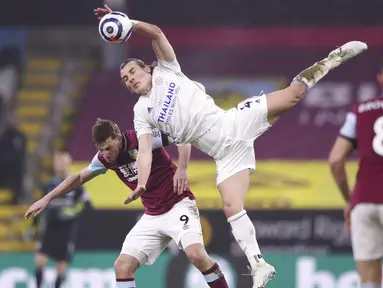 Pemain Leicester City, Caglar Soyuncu, berebut bola dengan pemain Burnley, Chris Wood, pada laga Liga Inggris di Stadion Turf Moor, Rabu (3/3/2021). Kedua tim bermain imbang 1-1. (Alex Pantling/Pool via AP)