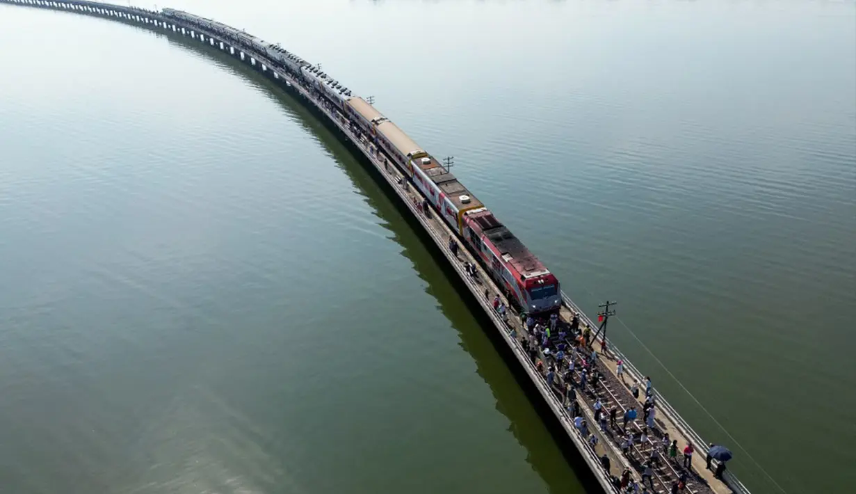 Wisatawan yang menaiki "Kereta Apung" yang populer mengambil foto di sepanjang rel kereta api saat berhenti di tengah Bendungan Pasak Jolasid, waduk terbesar Thailand di Provinsi Lopburi, 4 November 2023. (MANAN VATSYAYANA/AFP)