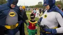 Dua pria dewasa bertopeng Batman ditemani Robin cilik saat diacara memecahkan rekor dunia untuk karakter buku komik terbanyak dunia, Washington DC, (18/4/2014) (AFP Photo/Paul J. Ricards).