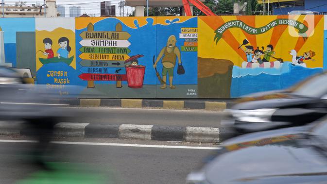 Kendaraan melintasi mural yang berisi pesan ajakan untuk menjaga lingkungan di Jalan Tambak, Manggarai, Jakarta, Selasa (11/2/2020). Mural tersebut bertujuan mengingatkan bahwa permasalahan lingkungan merupakan masalah serius yang harus dihadapi bersama. (Liputan6.com/Herman Zakharia)