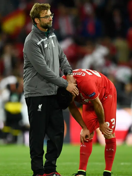 Pelatih Liverpool, Jurgen Klopp memberi semangat gelandang Emre Can usai pertandingan melawan Sevilla pada final liga Europa di Basel, Swiss (19/5). Liverpool kalah dari Sevilla dengan skor memalukan 3-1. (REUTERS /Dylan Martinez)