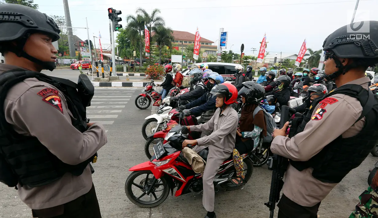 Dua polisi bersenjata laras panjang berjaga di jalur pantura Jalan Jenderal Ahmad Yani, Bypass, Kota Cirebon, Kamis (22/6). Pasukan bersenjata lengkap diterjunkan untuk mengantisipasi gangguan keamanan selama arus mudik Lebaran  (Liputan6.com/Johan Tallo)