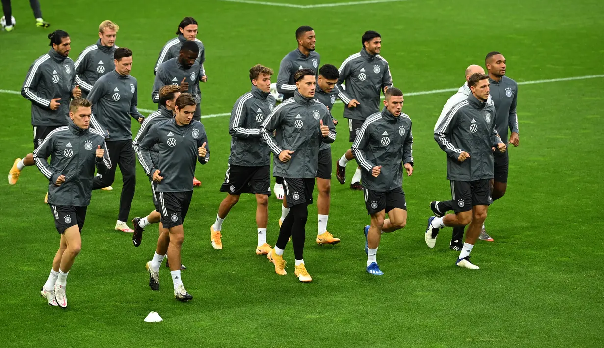 Para pemain timnas Jerman melakukan pemanasan saat sesi latihan di stadion Rheinenergie di Cologne, Jerman barat (9/10/2020). Jerman akan bertanding melawan Turki pada laga persahabatan di stadion Rheinenergie di Cologne, Jerman, Kamis (8/10/2020). (AFP/Ina Fassbender)