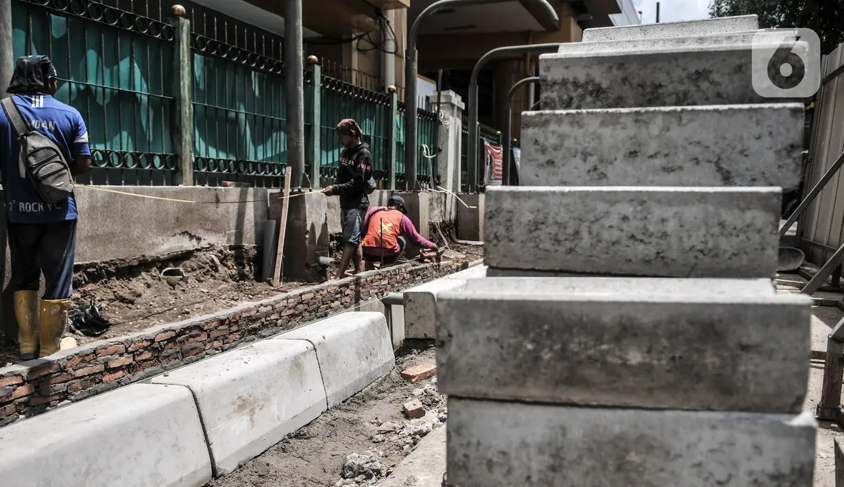 Pekerja saat menyelesaikan pembangunan jalur pedestrian atau pejalan kaki di Stasiun Gondangdia, Jakarta Pusat, Kamis (8/4/2021). Stasiun Gondangdia akan menjadi salah satu stasiun terpadu yang pembangunannya meliputi penataan pedestrian, tempat khusus bagi pedagang. (merdeka.com/Iqbal S. Nugroho)